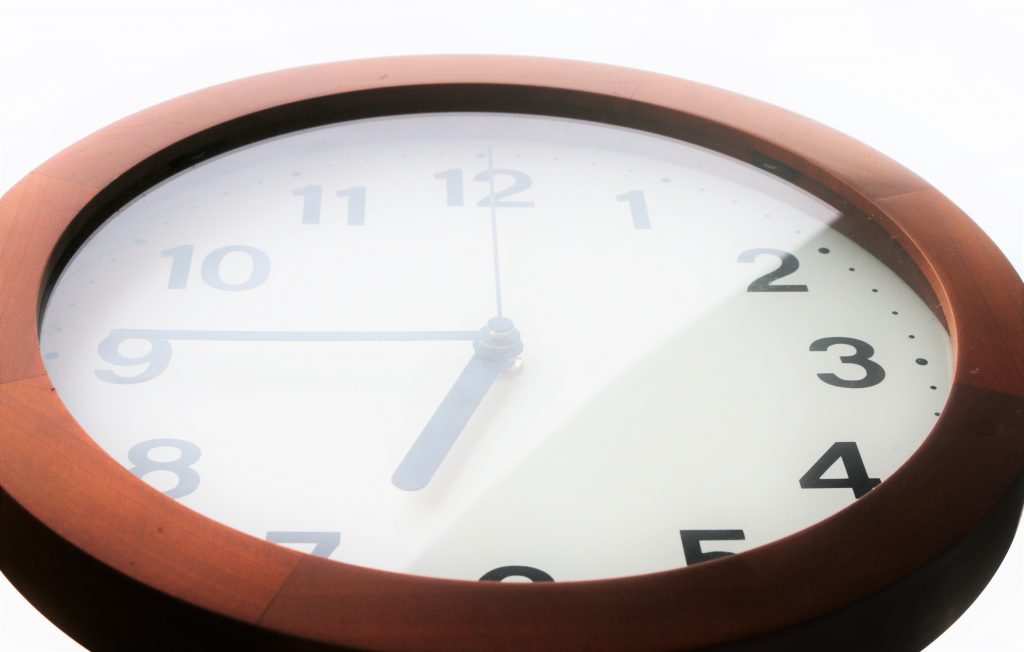 光の中で6:45を指し示す時計