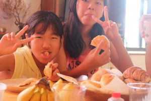 朝食のパンを食べる姉妹
