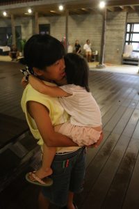 疲れて寝てしまった三女を抱く次女