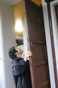 外の雨戸を閉める夫