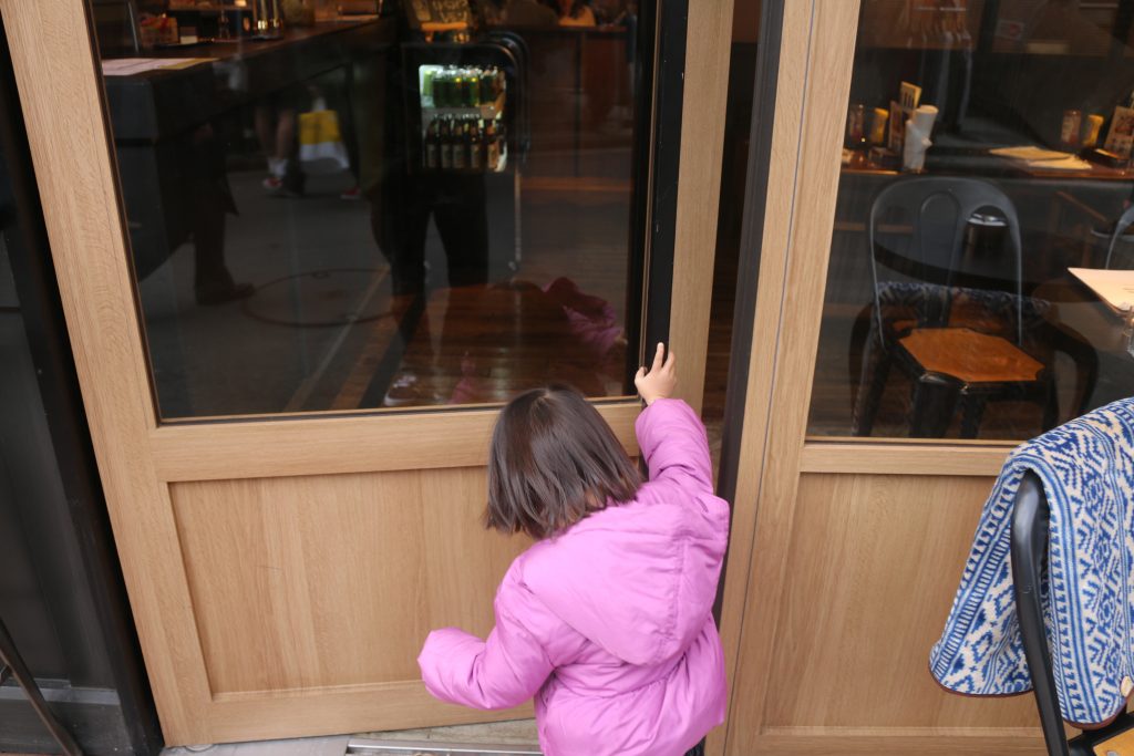 レストランのドアを開ける幼児