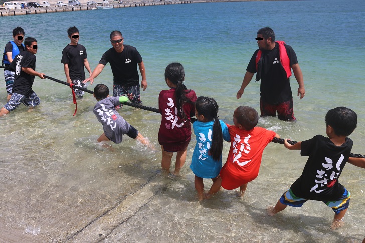 子どもたちが海で綱引き